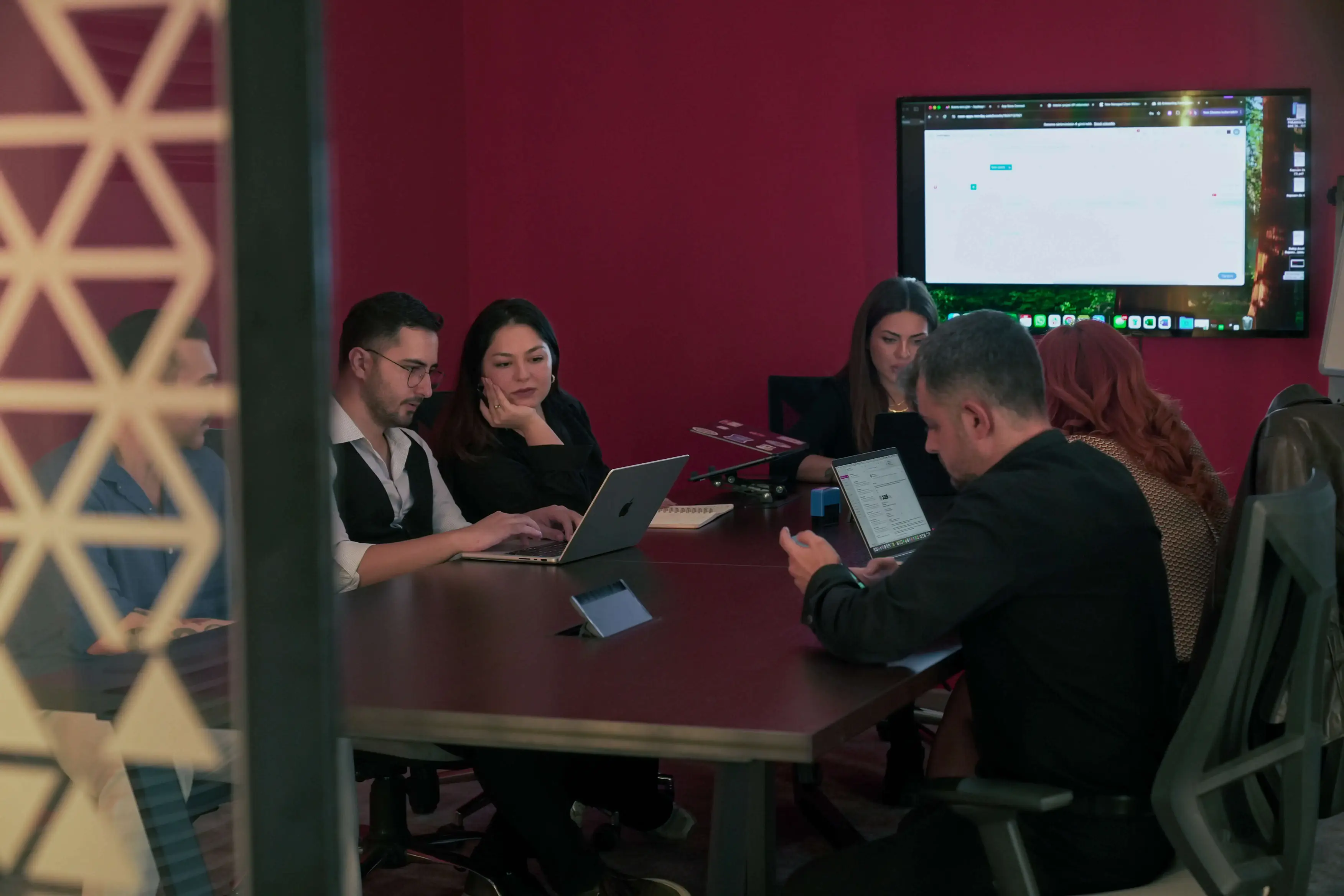 A client review in the meeting room, seen through the glass partition