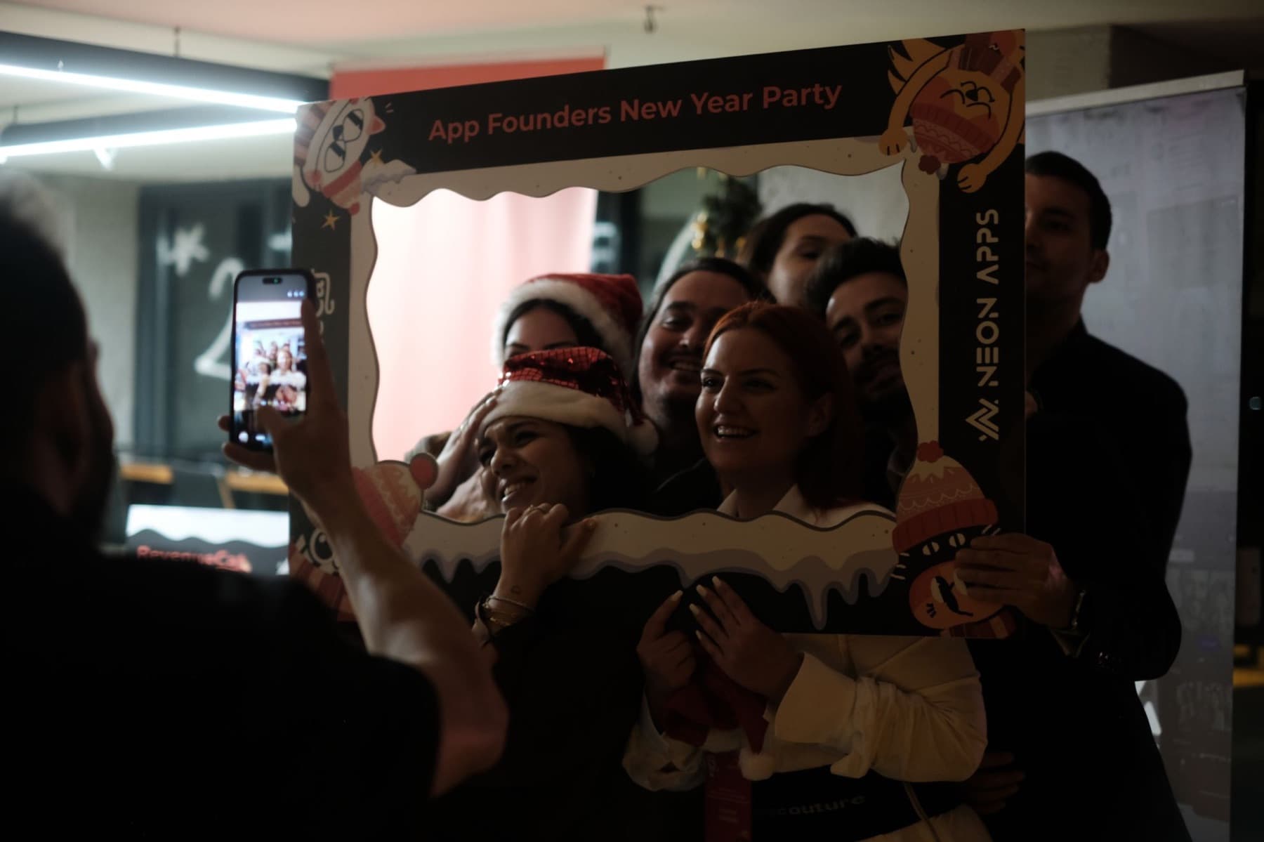 Guests posing in the App Founders New Year Party photo frame at the Neon Apps office in Istanbul, December 2025