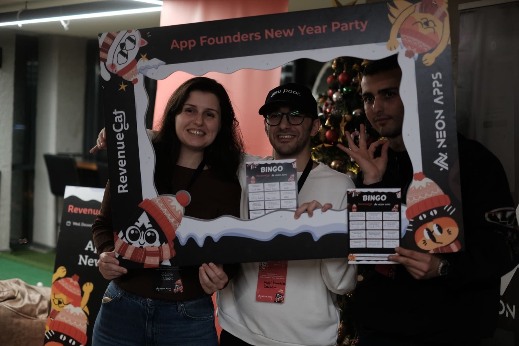 Founders holding RevenueCat and Neon Apps bingo cards at the App Founders New Year Party photo frame in Istanbul, December 2025