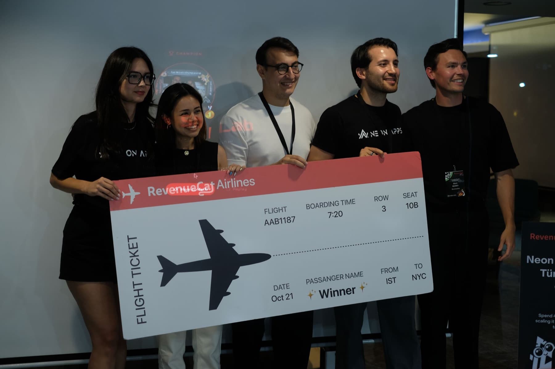 The winning team of the Neon Apps and RevenueCat App Growth Championship holding an oversized RevenueCat Airlines ticket from Istanbul to New York